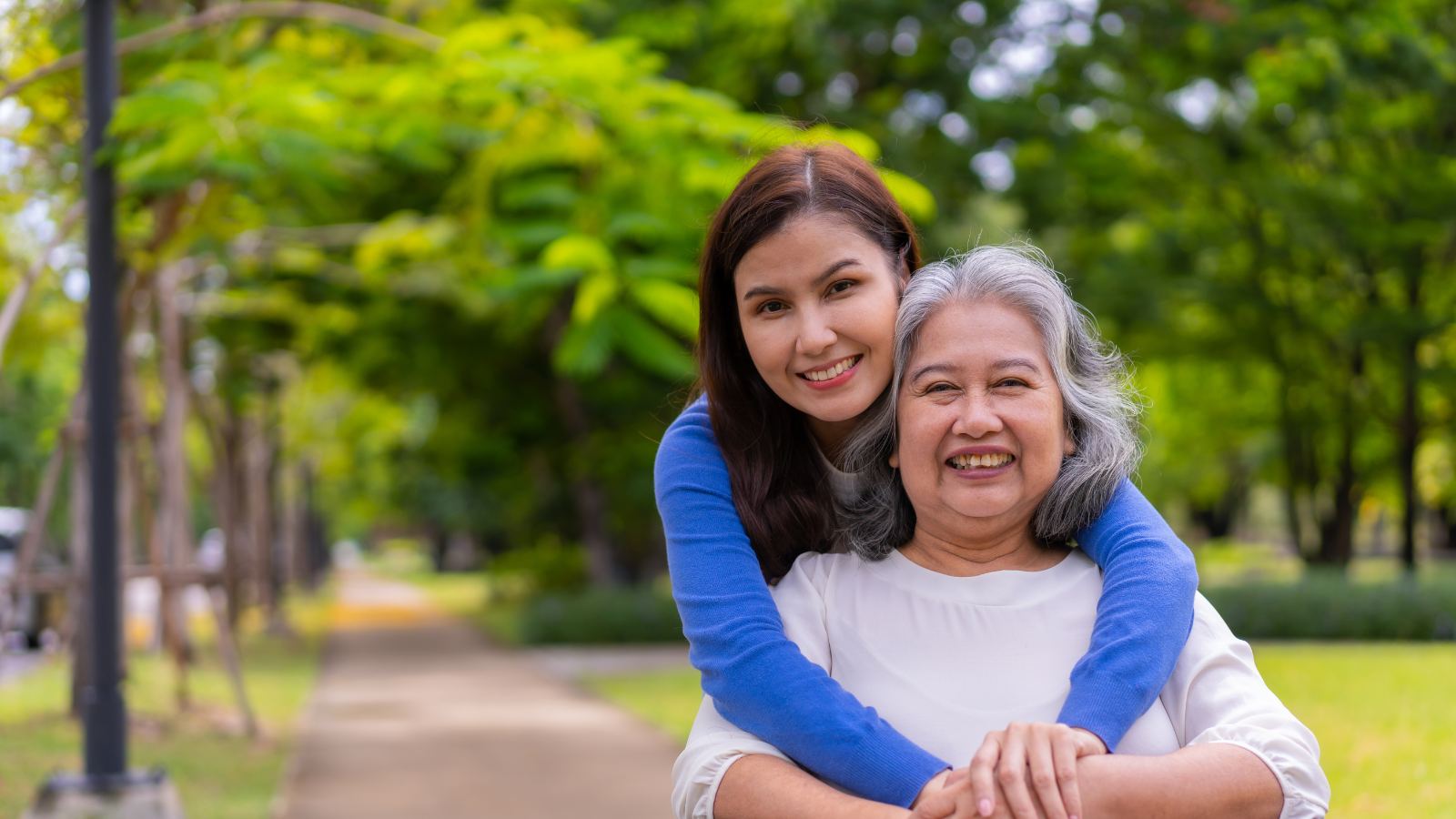 Younger and older woman hugging and smiling
