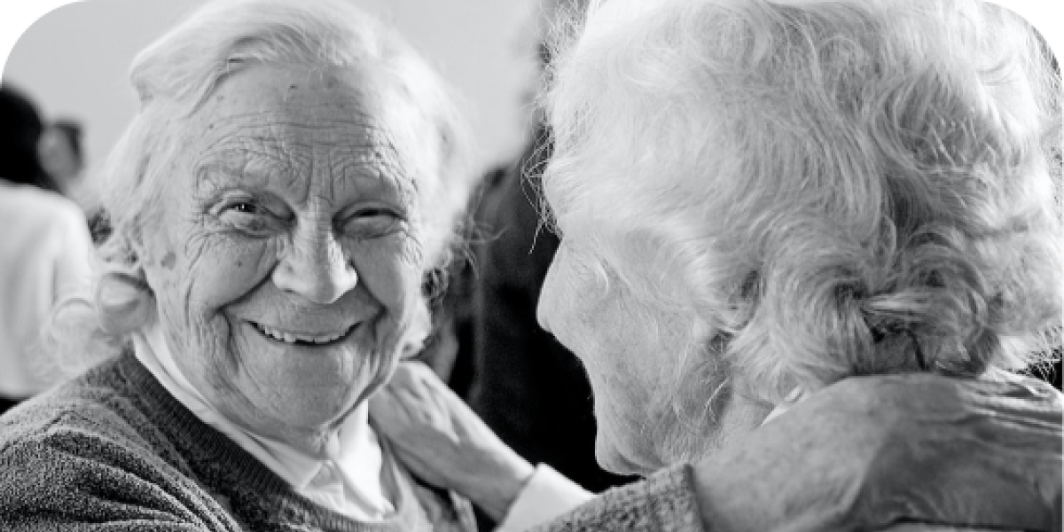 Two ladies, one smiling at camera, one looking away